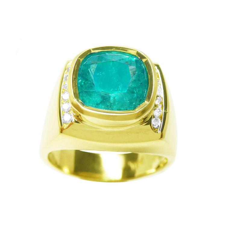 This men's gold ring with a large cushion cut natural colombian emerald is on a topside view and sideways are visibles.