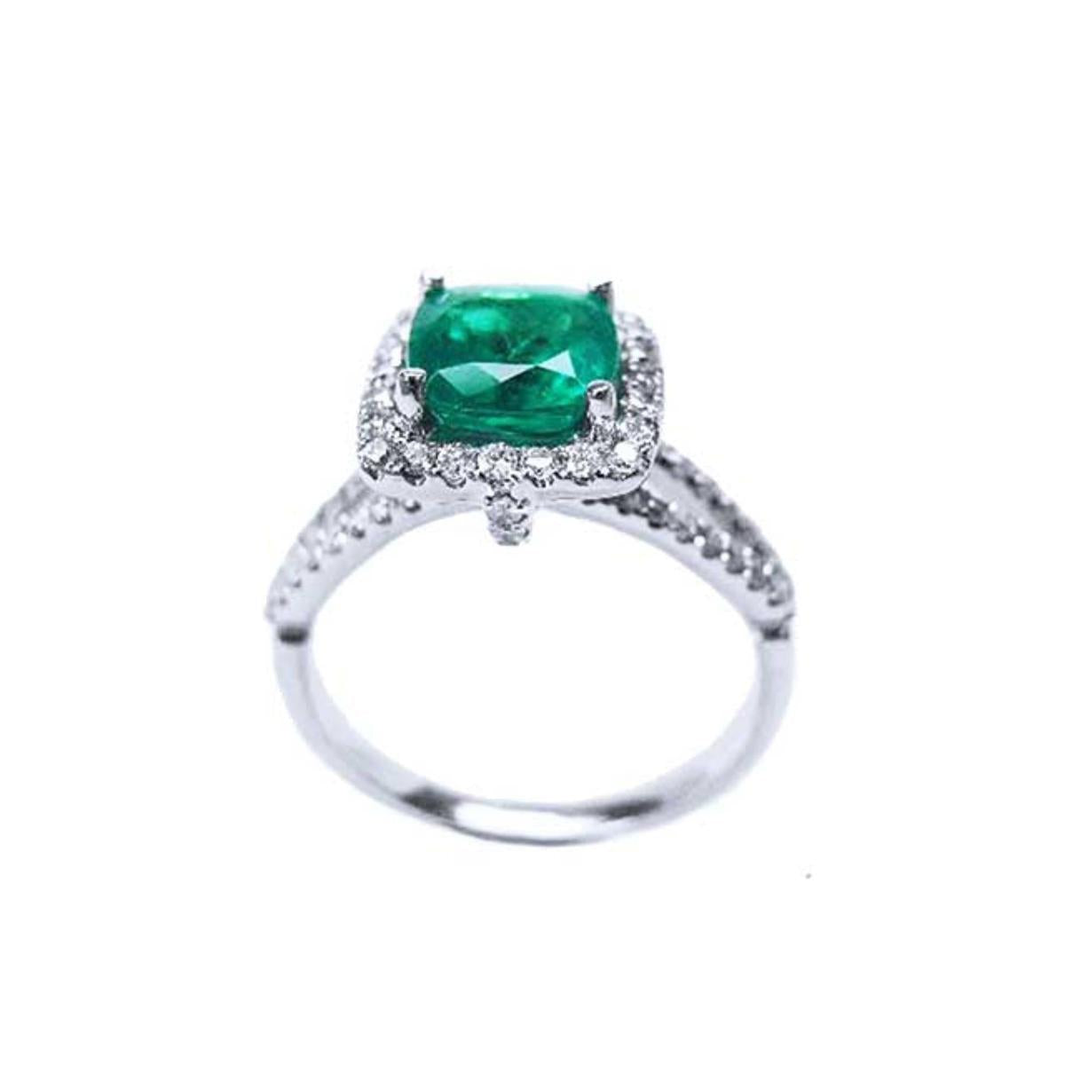 A 18k white gold emerald ring cushion cut and diamonds on a white background.