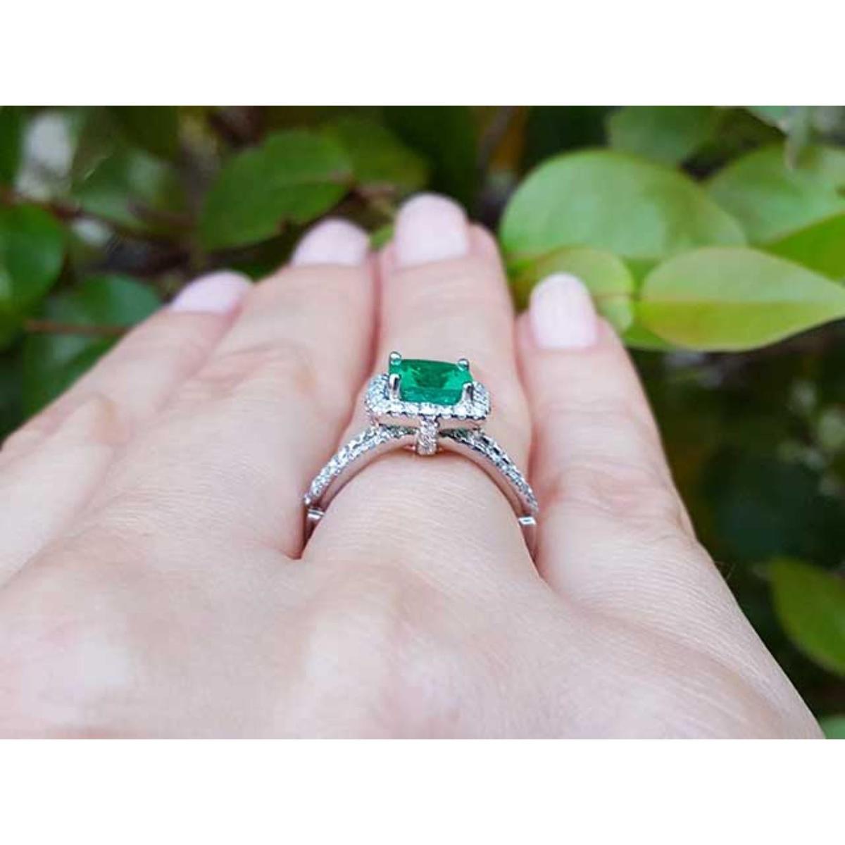 Emerald ring on a hand with a natural background.