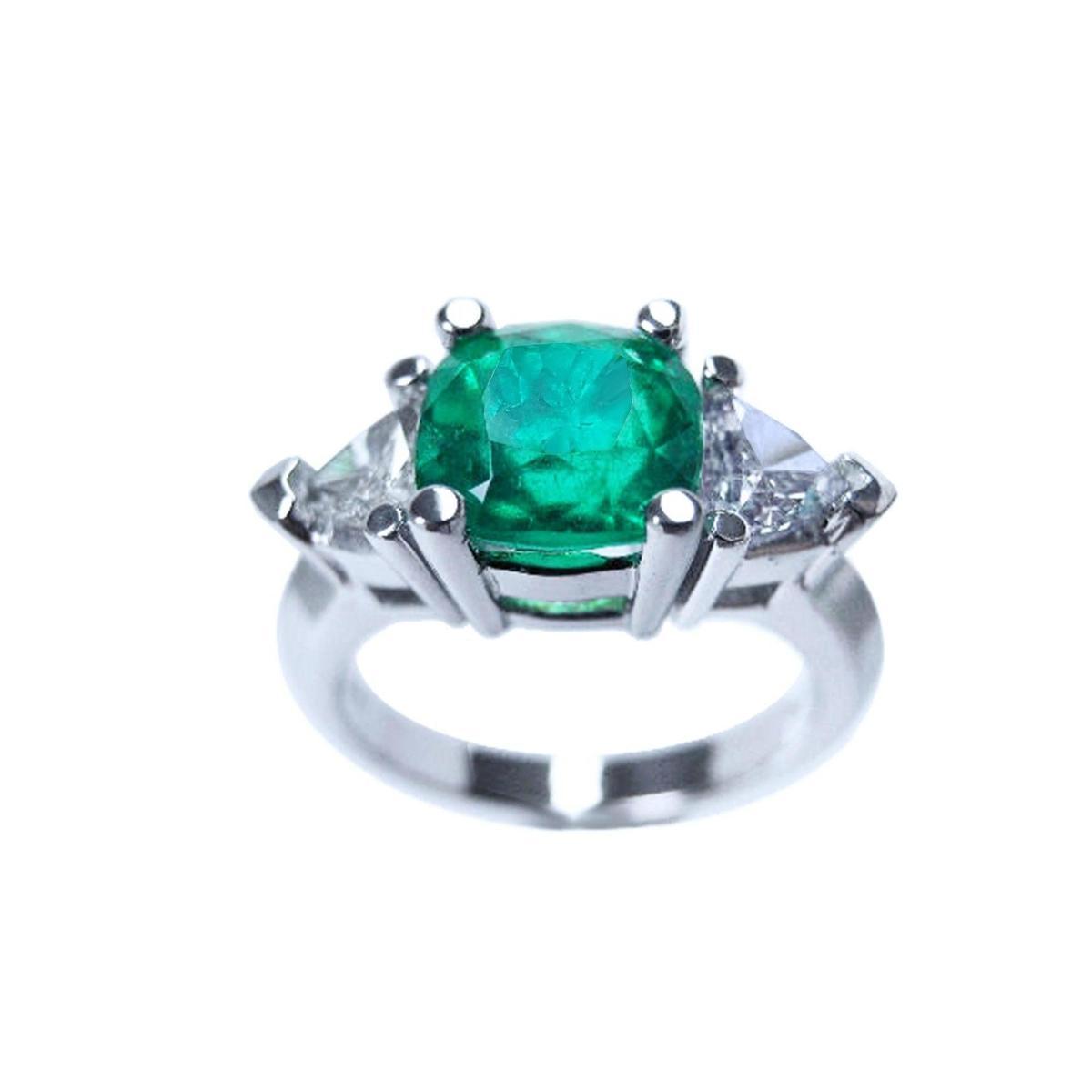 Emerald cushion cut trillion accent diamonds ring for women on a white background.