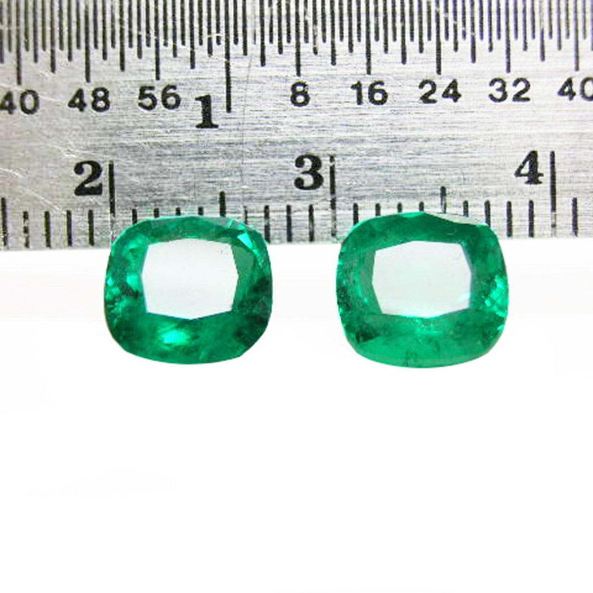 Matching pair cushion cut loose colombian emeralds front side table and crown view with ruler sizer