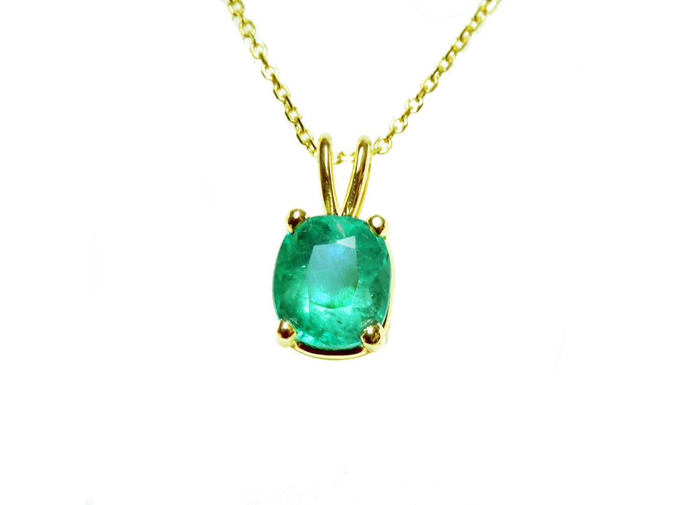 A yellow gold natural emerald cushion cut pendant on a topside view position.