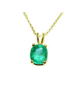A 14k yellow gold natural Muzo mine colombian emerald cushion cut pendant prong set.