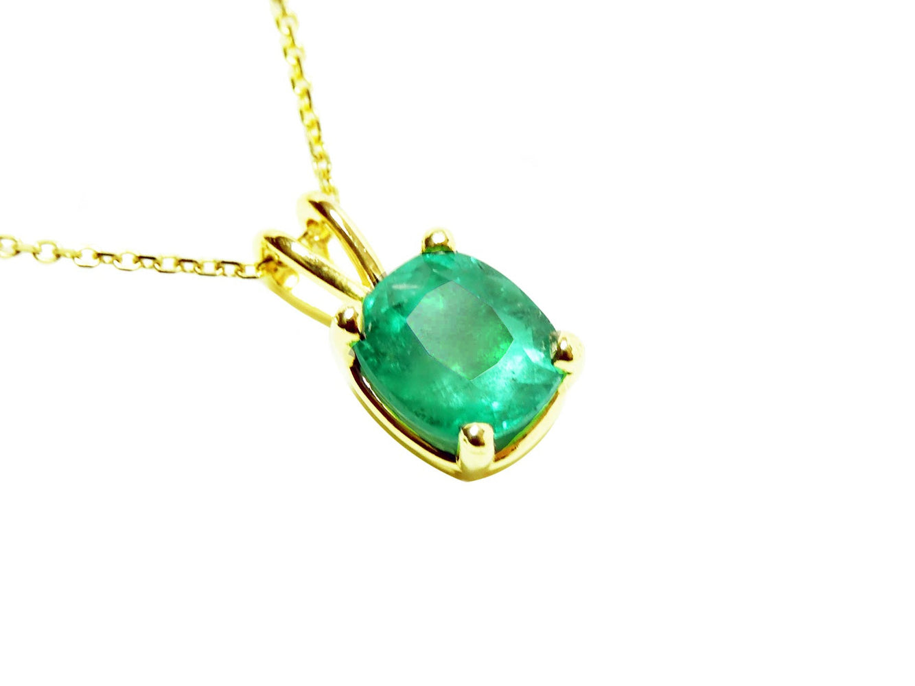A cushion cut emerald pendant displaying its topside profile ona right side position.