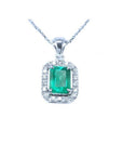 Emerald-cut emerald pendant with halo diamonds in 14K white gold on a chain.