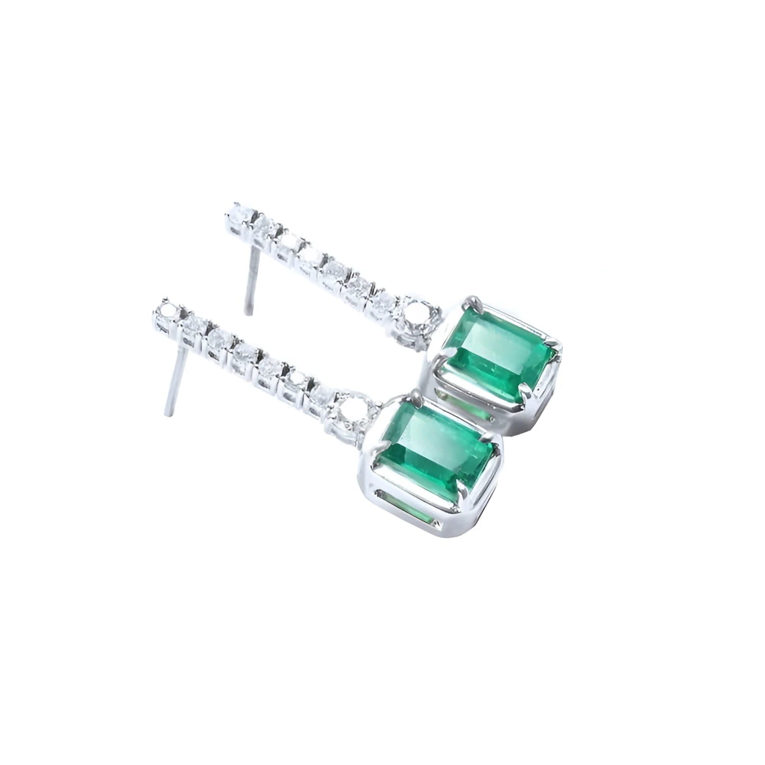 Dangling 18K white gold earrings with emerald-cut Colombian emeralds and diamond studs.