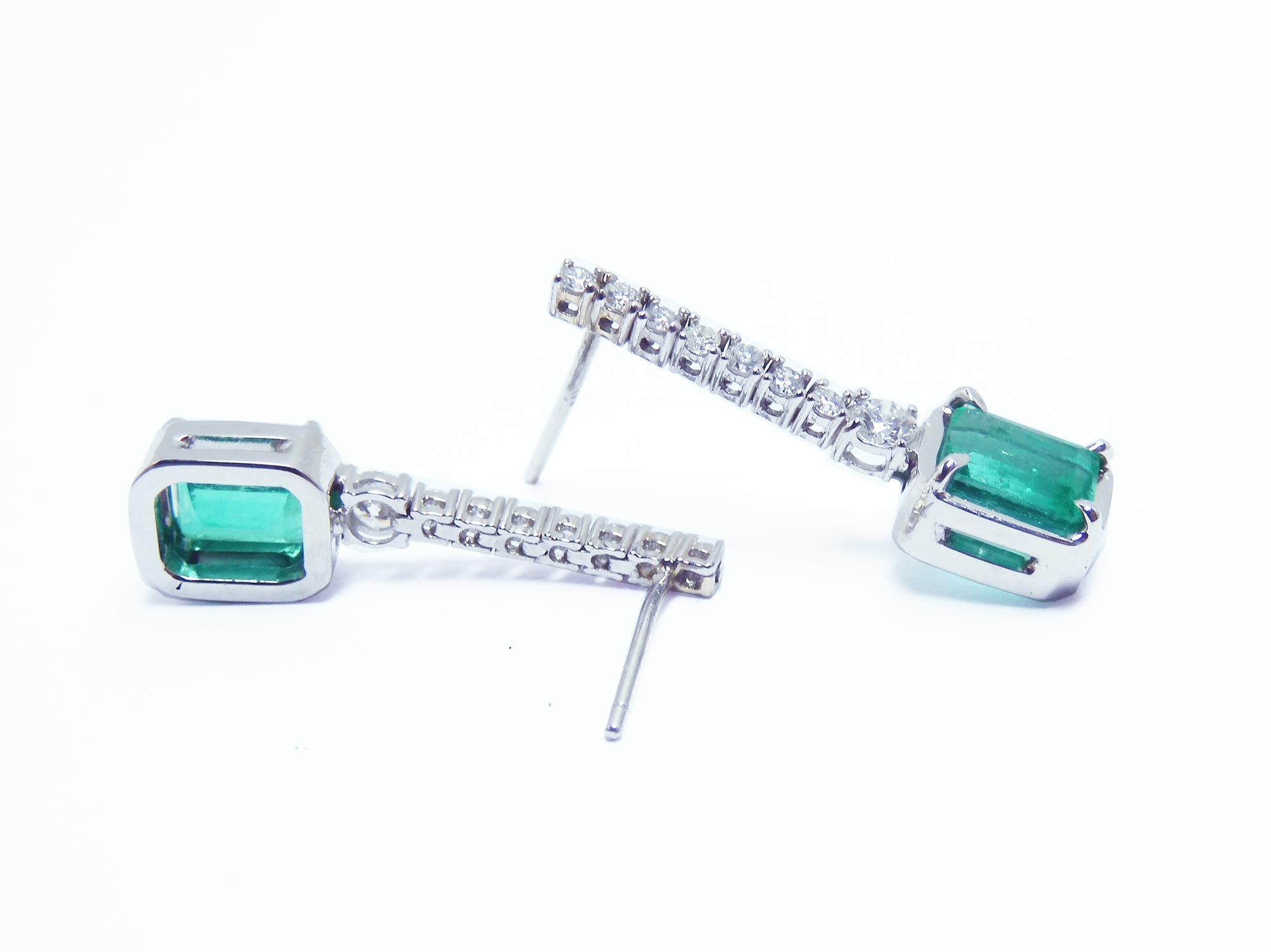 Pair of 18k white gold emerald dangle earrings underside and upside-down view