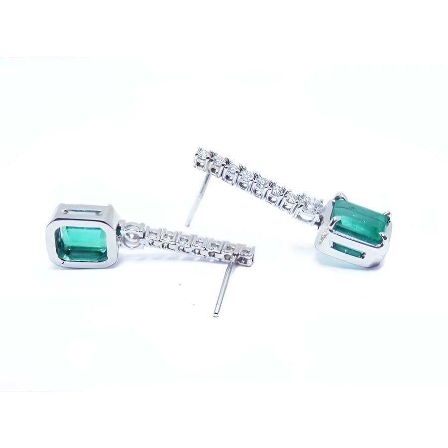 18K white gold dangling emerald-cut emerald earrings with diamond-studded straight lines.