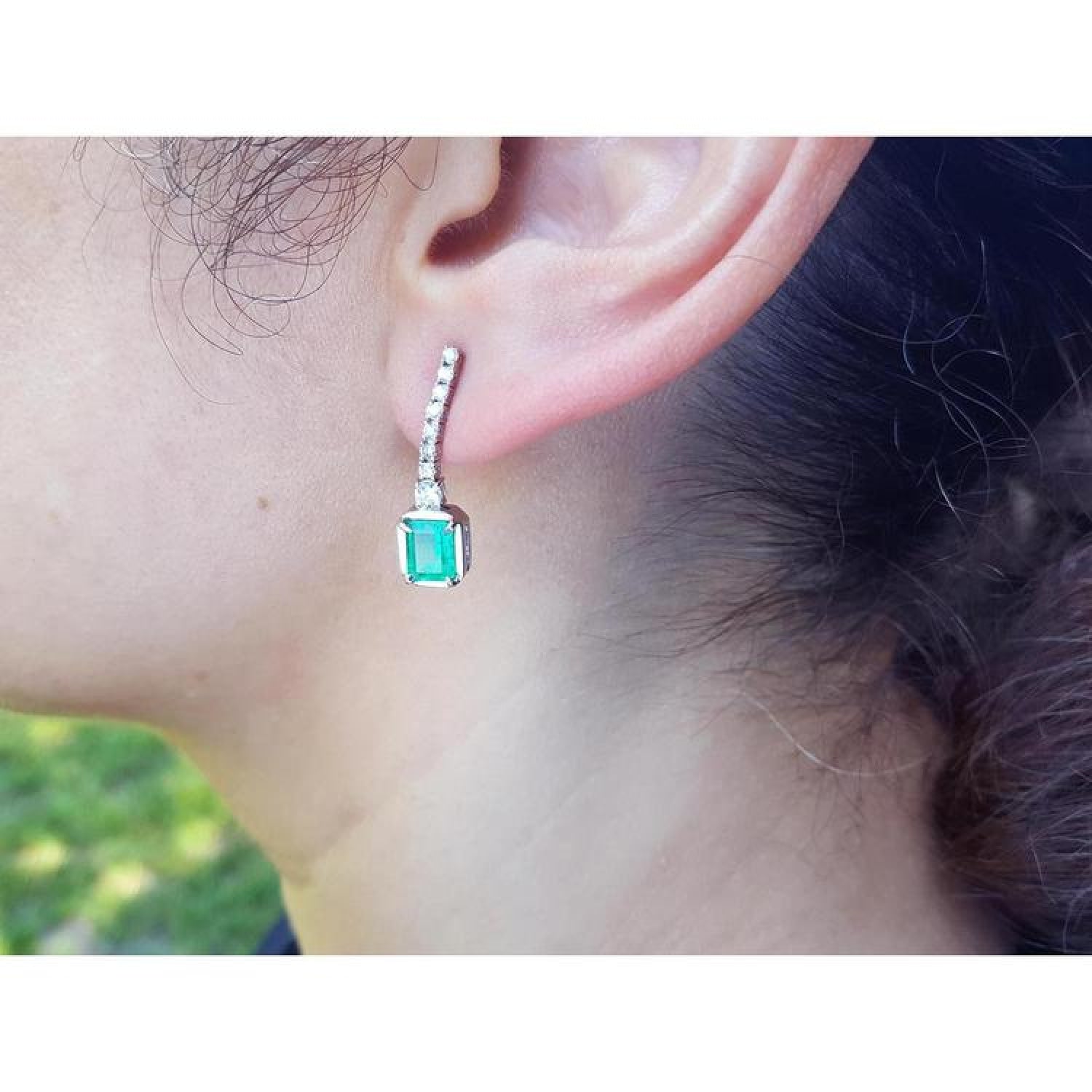 18K white gold emerald-cut emerald dangling earrings with diamond-studded straight line.