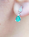 Close-up of an emerald teardrop earrings on a woman's ear