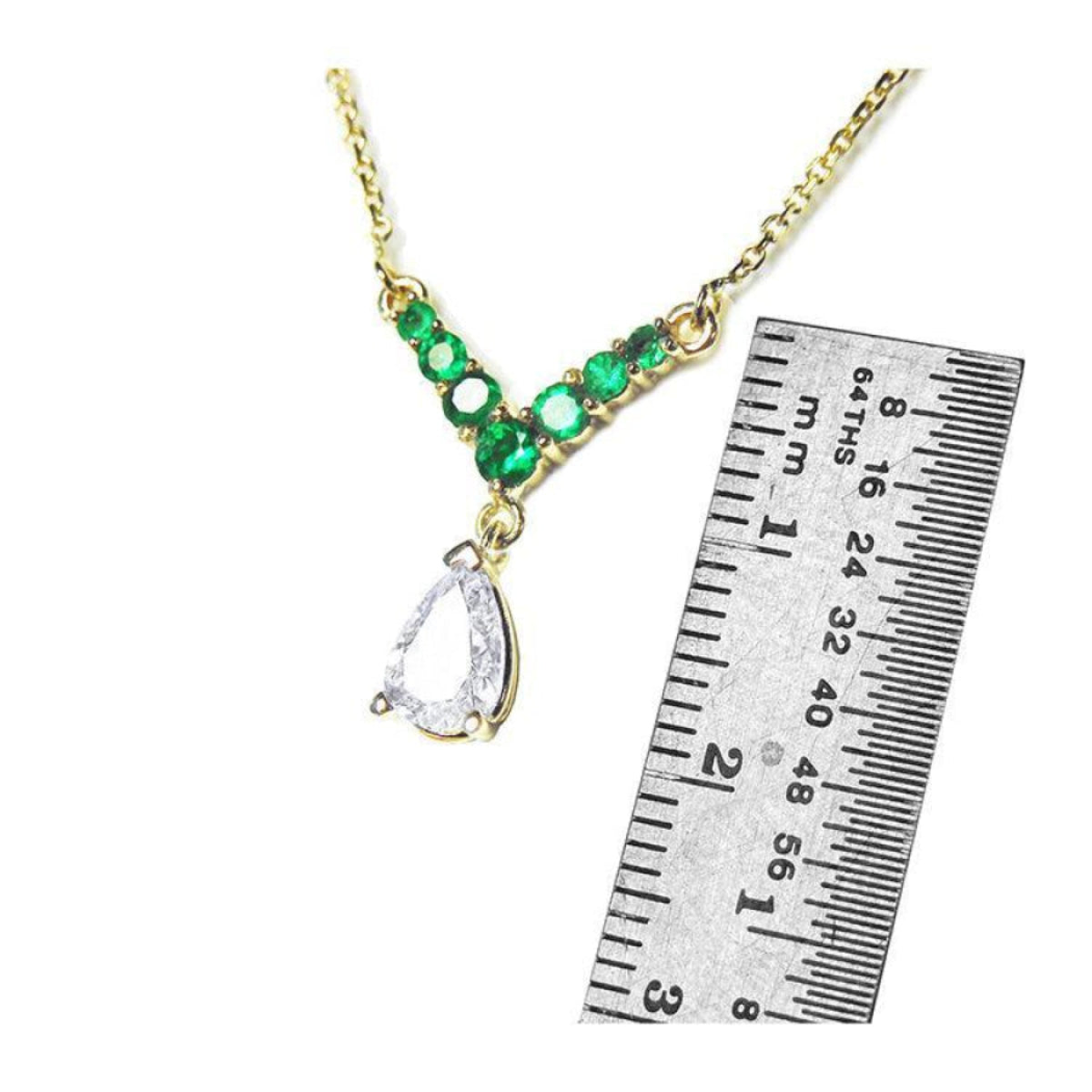 14K gold necklace with pear-cut diamond and seven round emeralds, shown with ruler for scale.