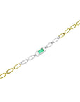 A distant view of this paperclip bracelet with white and yellow gold links and a green emerald and diamonds.