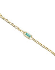 Gold bracelet with a central emerald stone and natural diamond accent on a white background.