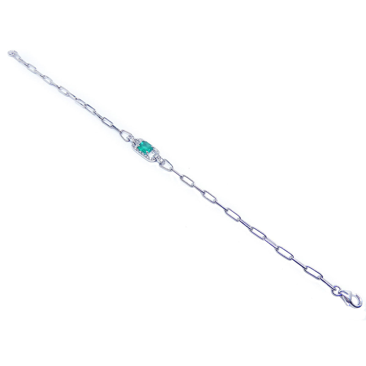 A distant view of a white gold paperclip emerald bracelet.