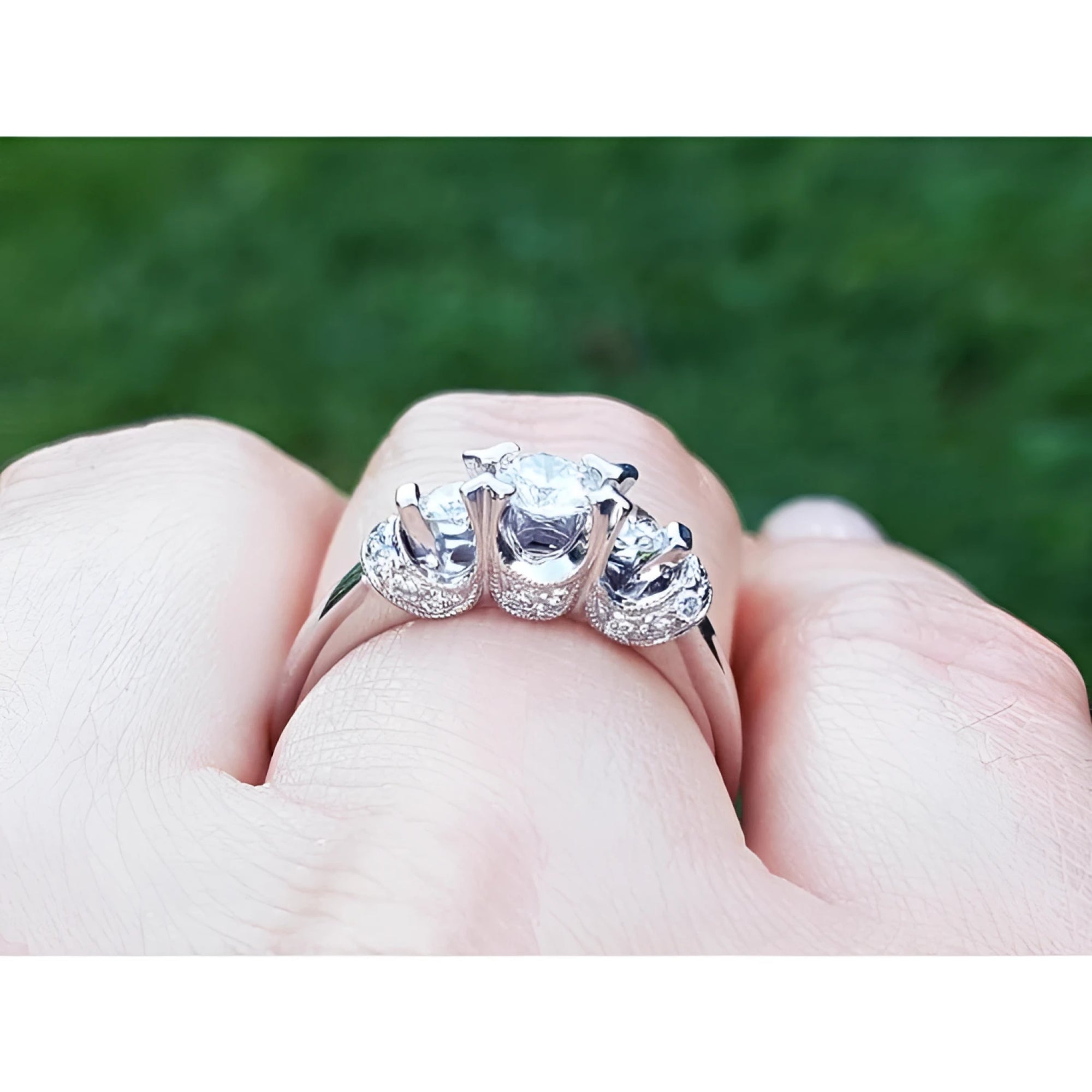 14K white gold three-stone engagement ring with round cut natural diamonds and pave set accents.