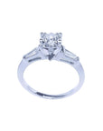 14k white gold engagement ring with a round central diamond and two baguette side diamonds.