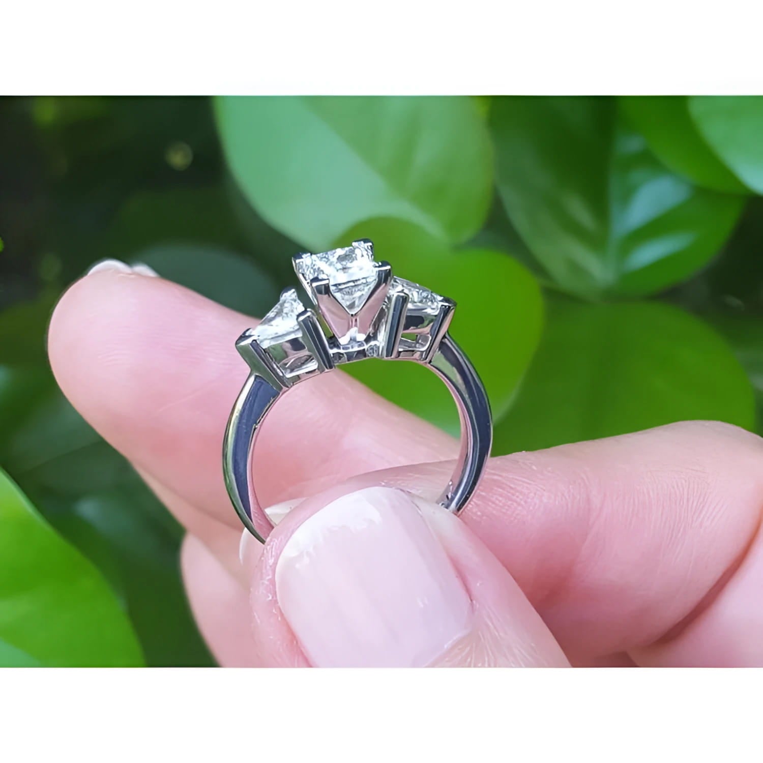 14K white gold ring with a princess cut diamond center and two trillion side diamonds.