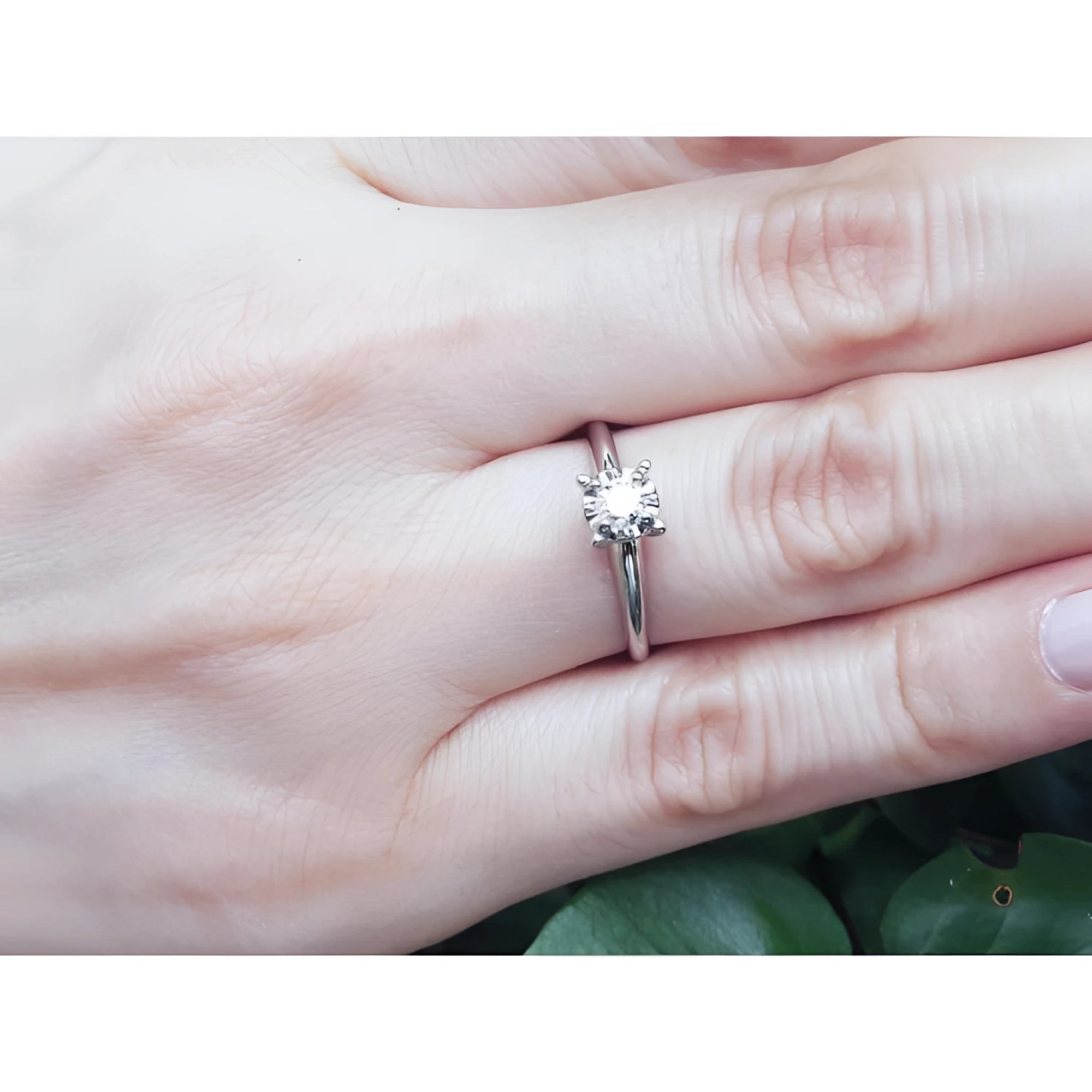 Round cut diamond solitaire engagement ring in 14K white gold on a hand.