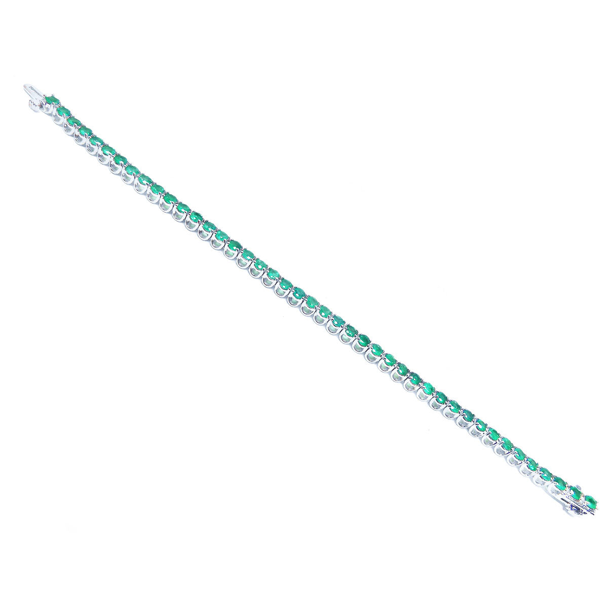 A distant view of a colombian emerald tennis bracelet in white gold on a white background.