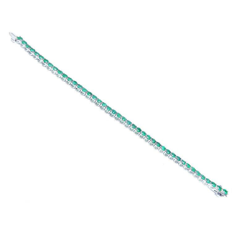 Colombian emerald tennis bracelet with round cut green emeralds in 14K white gold.