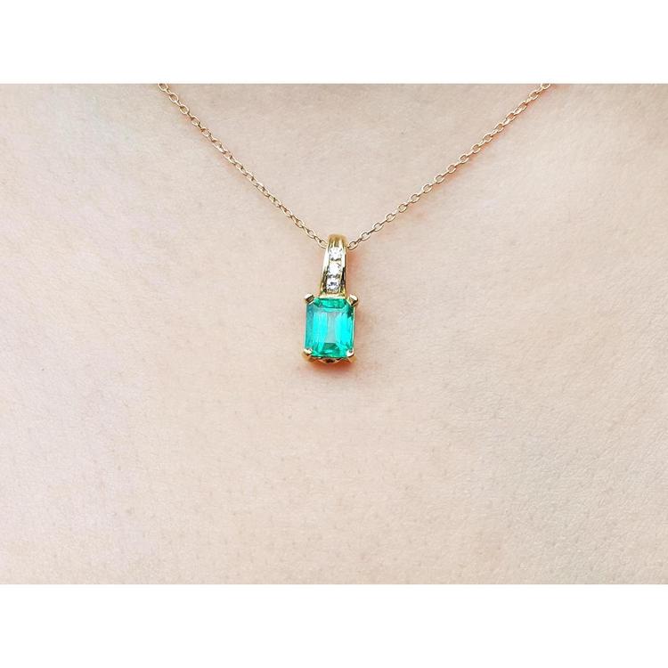 14K yellow gold pendant with a rectangular Colombian emerald and diamond accents on a delicate chain.