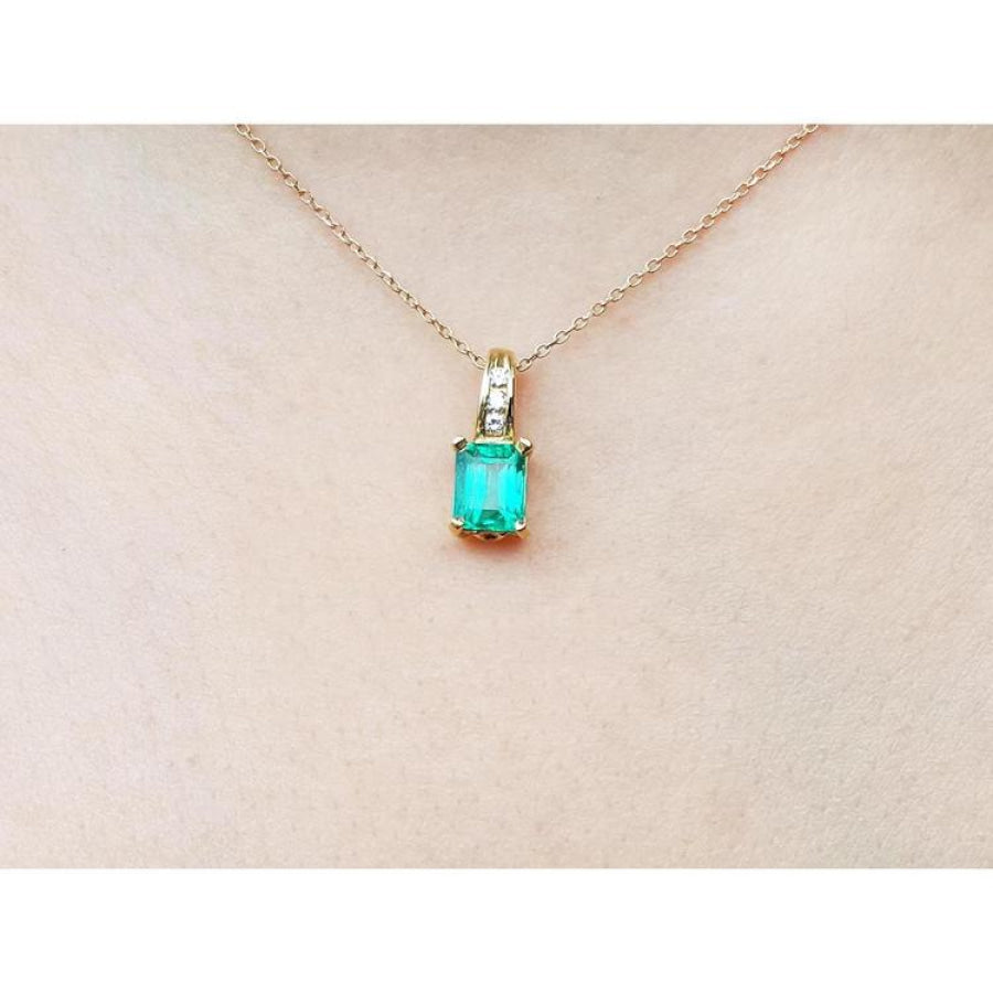 14K yellow gold pendant with a rectangular Colombian emerald and diamond accents on a delicate chain.