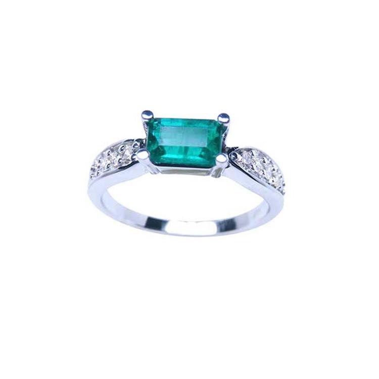 0.90 ct. East West emerald ring in 14k white gold with pave diamond accents.