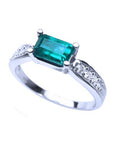 A rectangular emerald-cut natural emerald on top and side view of the band ring in white gold,