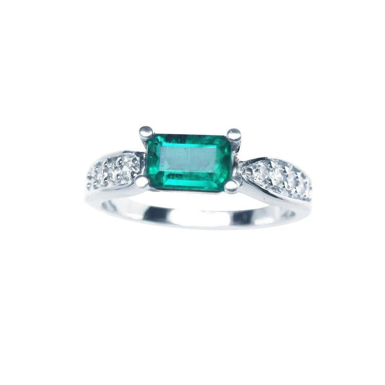 A Mother’s Day emerald white gold ring in an east-west style, featuring accent diamonds along the band.