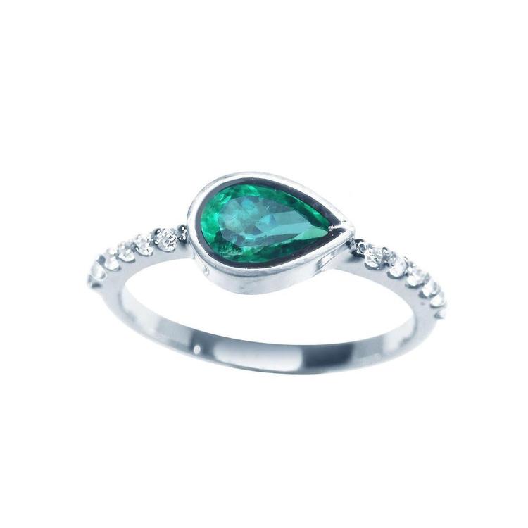 A teardrop colombian emerald bezel set ring with accent diamonds in 14k white gold for ladies.