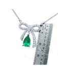 18K white gold bow-tie necklace with a pear-shaped deep green emerald.