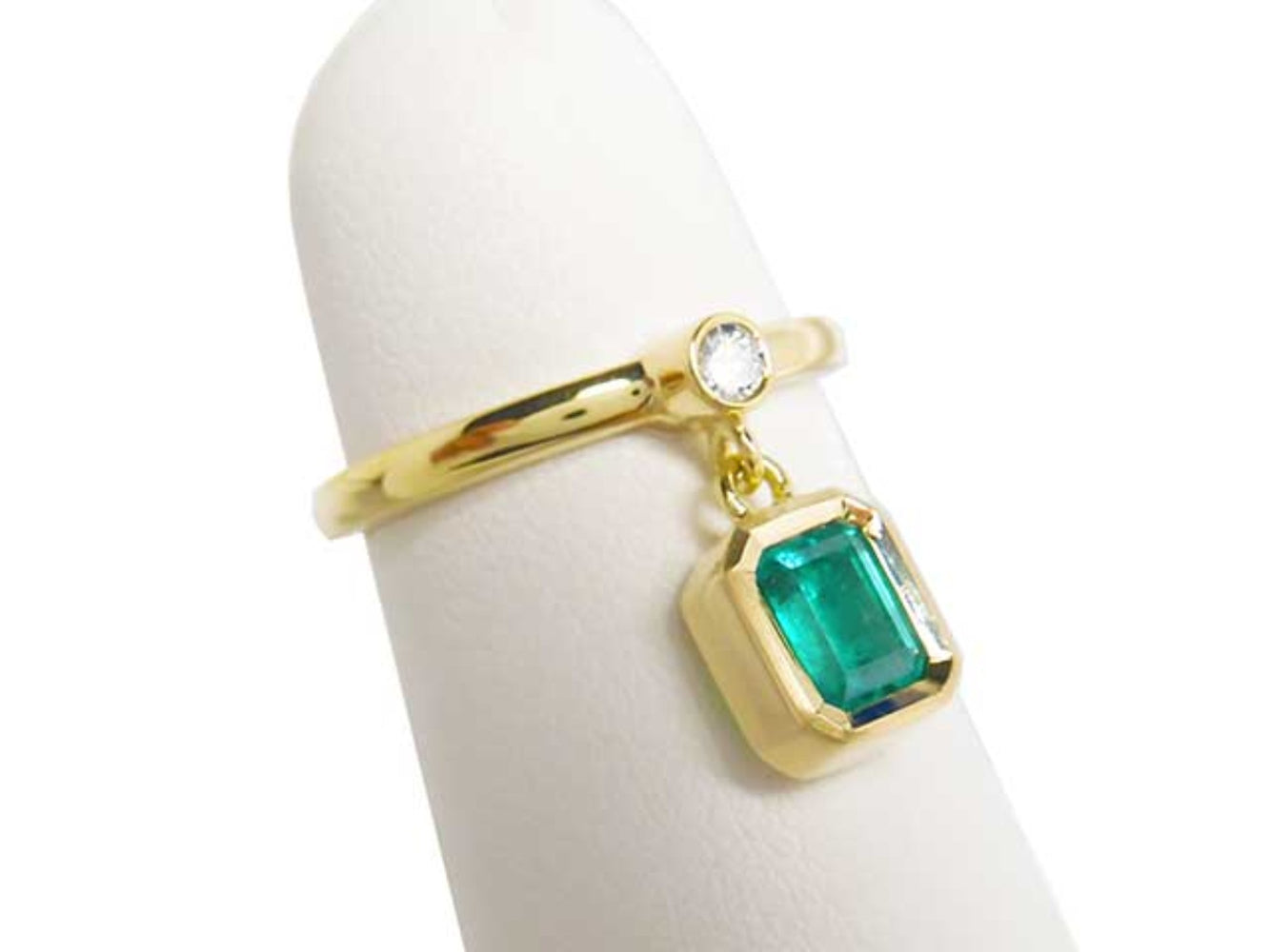 This is an emerald dangle ring representing May's birthstone jewelry displaying side profile.