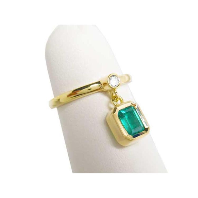 14K yellow gold ring with a bezel-set emerald dangle and a small round diamond accent.