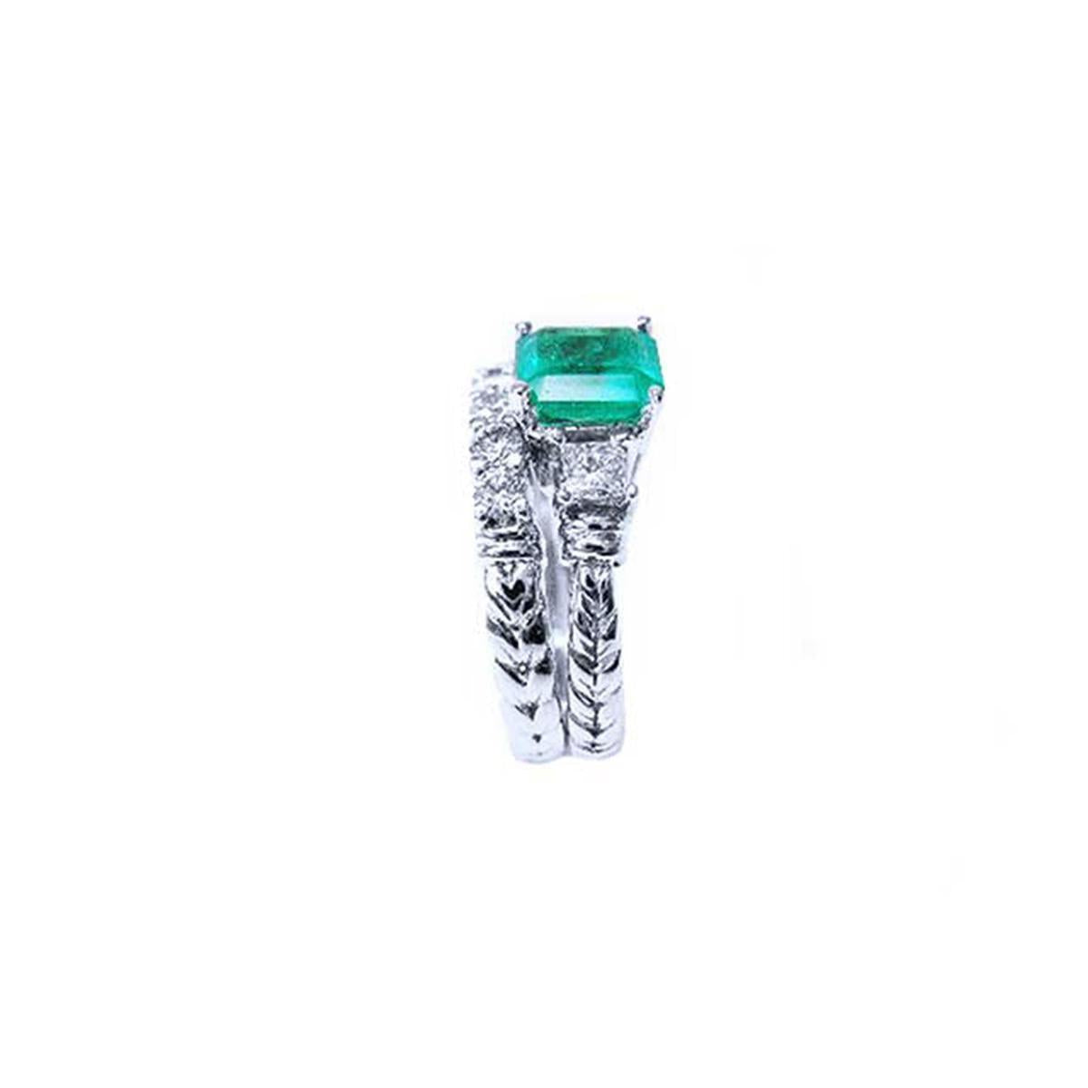 Side profile of a bridal's emerald engagement ring and matching wedding band white gold.
