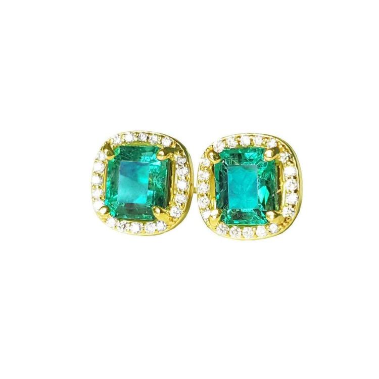 Pair of emerald stud earrings with halo diamond in yellow gold on a front position top view.