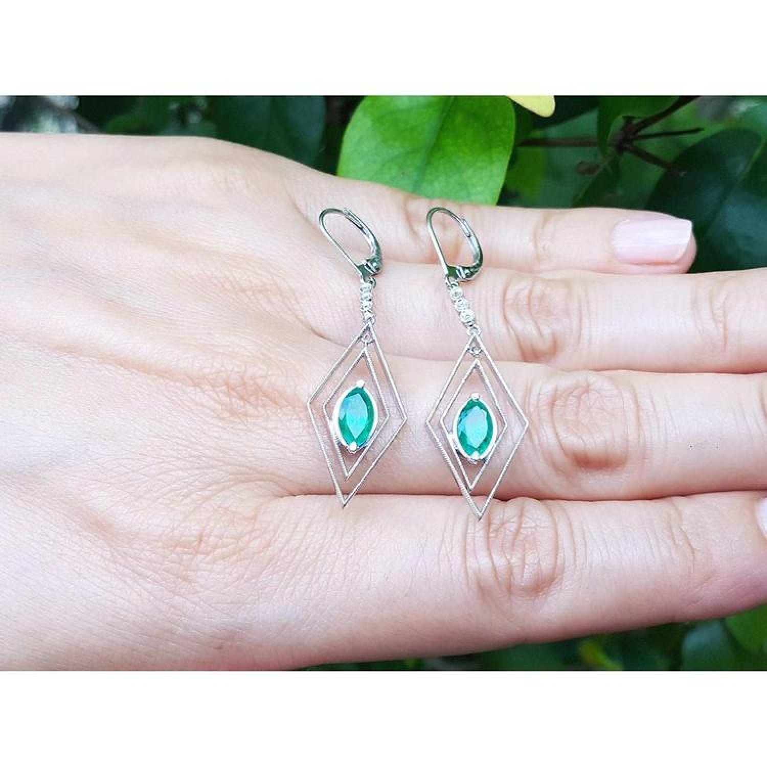 Deep bluish-green emerald marquise earrings in 14K gold with diamond lever backs, dangling from double marquise frames.