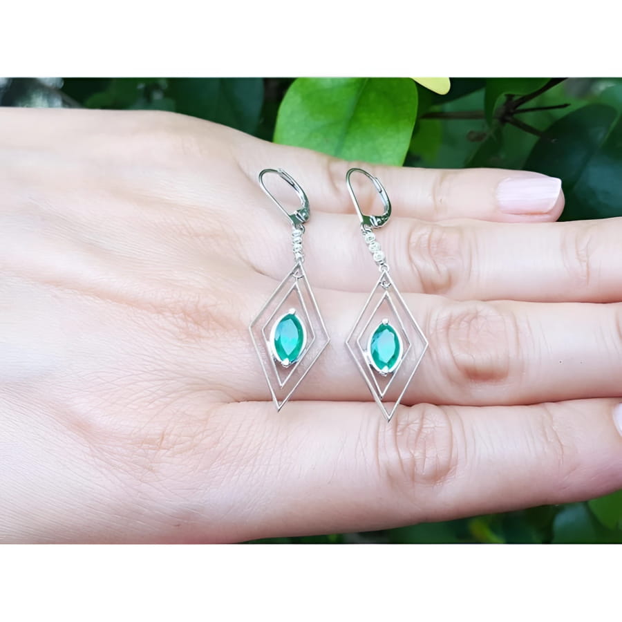Deep bluish-green emerald marquise earrings in 14K gold with diamond lever backs, dangling from double marquise frames.