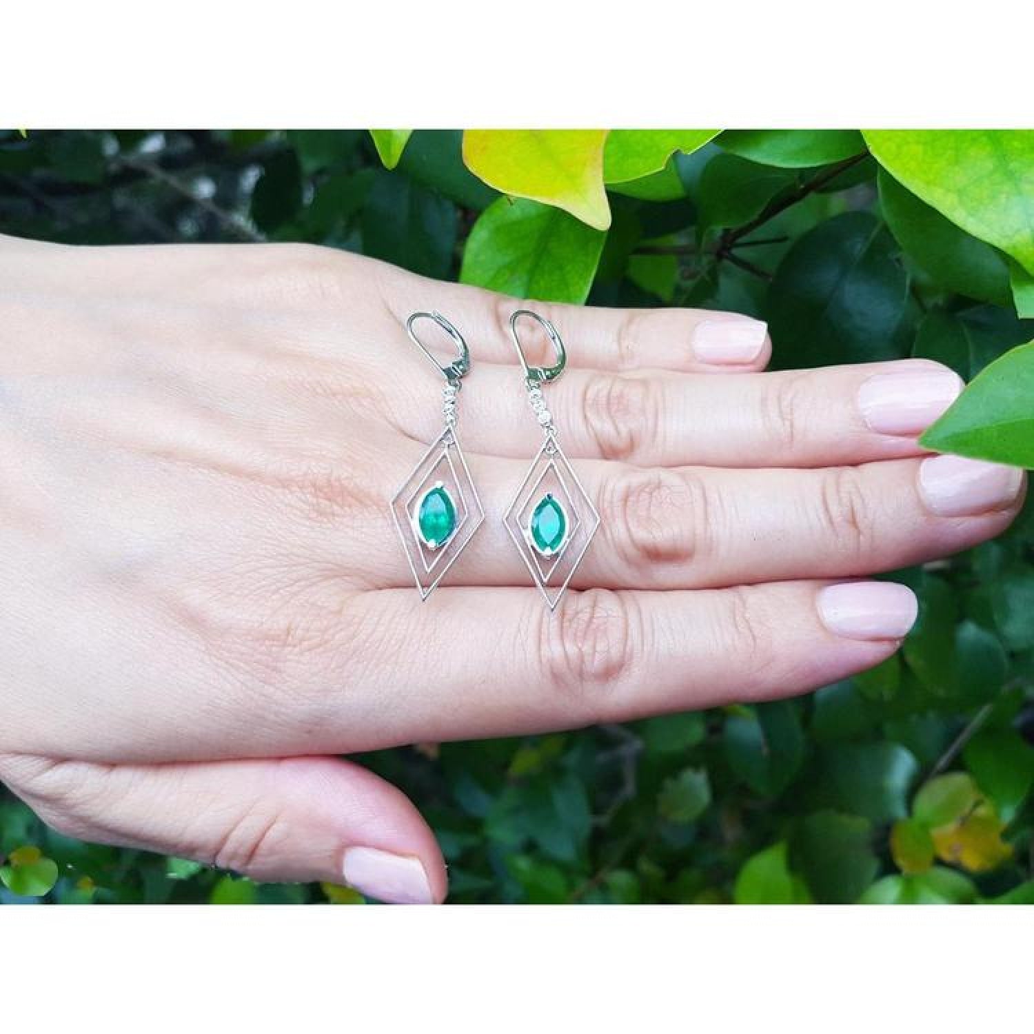 Deep bluish-green emerald marquise earrings in 14K gold with diamond accents, dangling from lever backs.