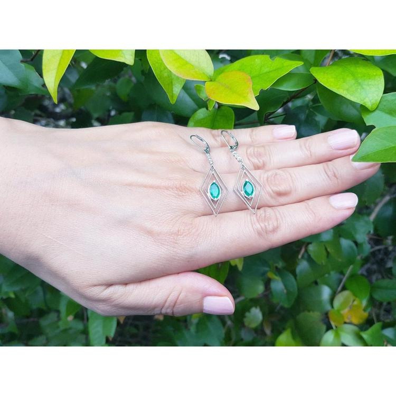 Emerald marquise earrings in 14K gold with deep bluish-green gems and diamond accents, dangling from lever backs.