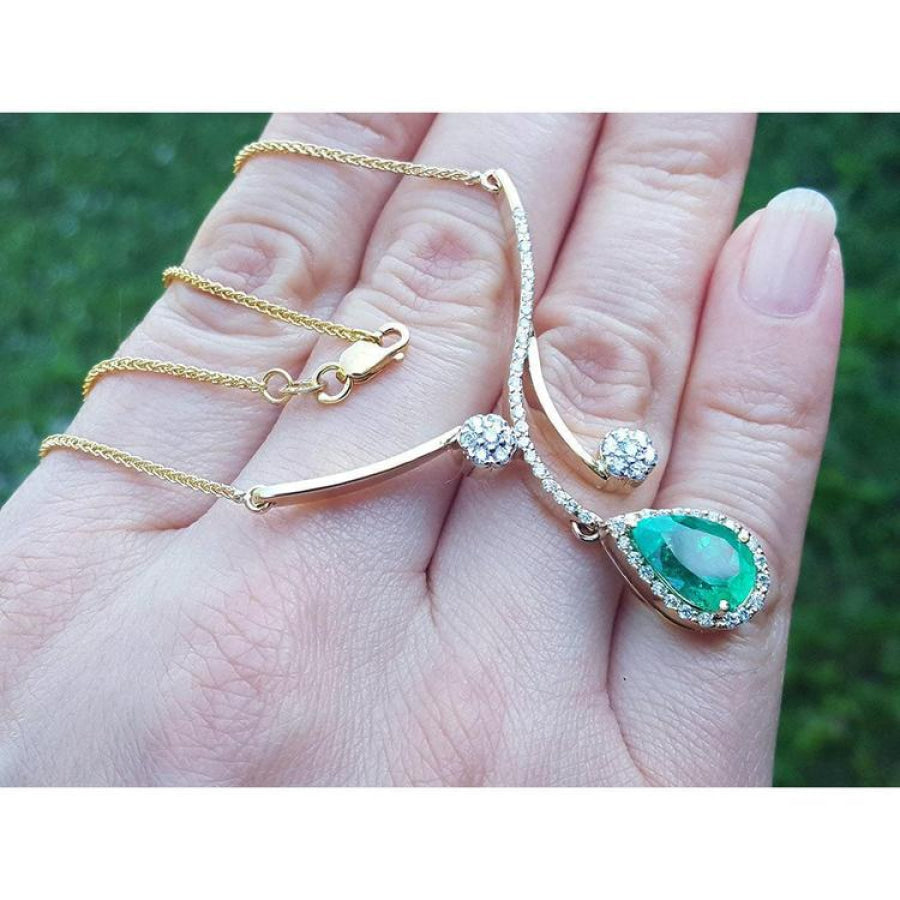 18K yellow gold necklace with a pear-shaped Colombian emerald and diamond clusters.