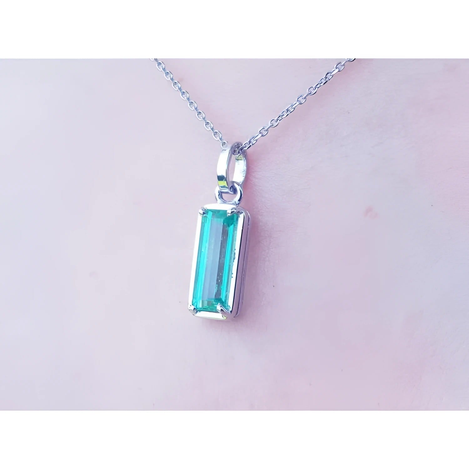 1.70 ct. rectangular Colombian emerald solitaire pendant in 14K white gold on a chain.