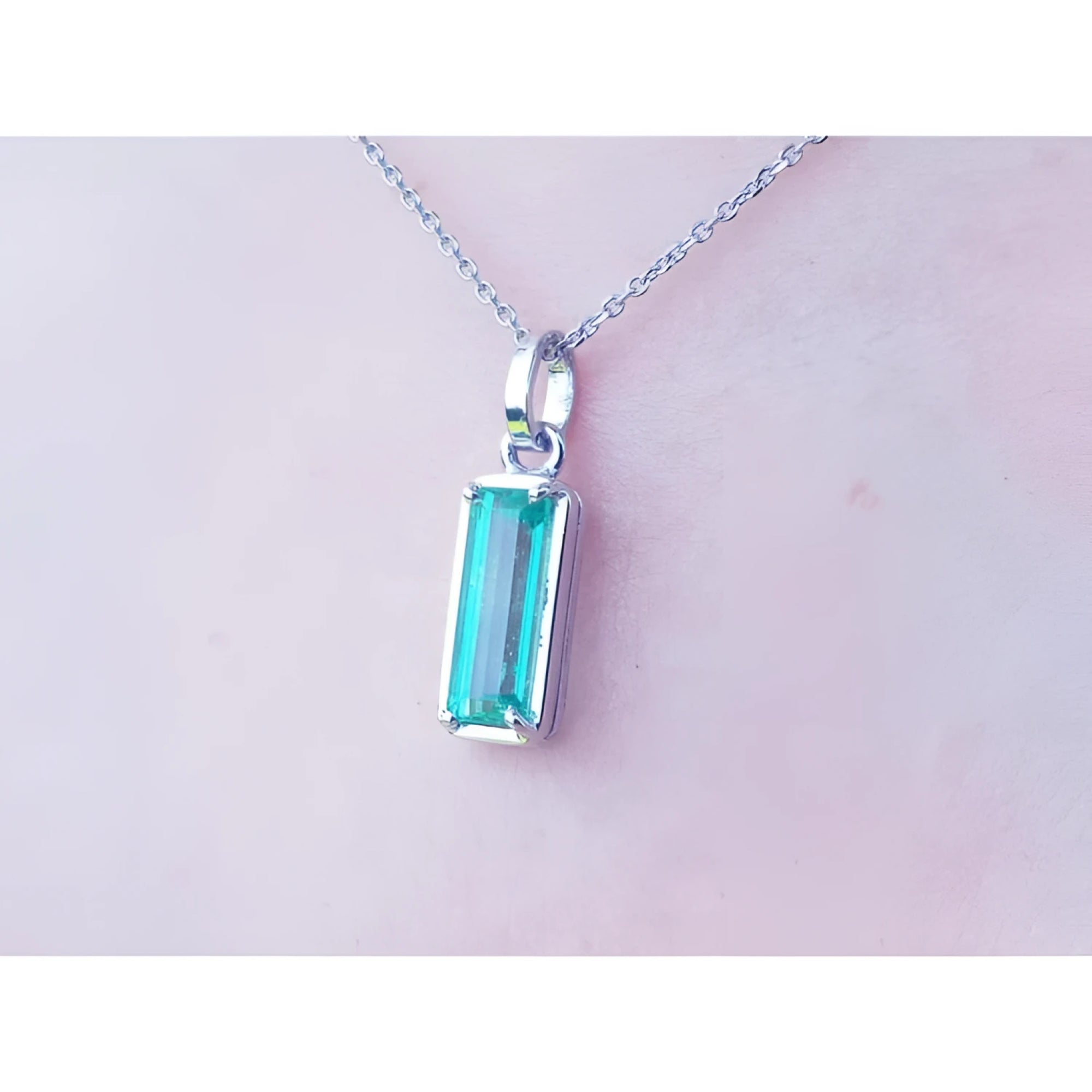 1.70 ct. rectangular Colombian emerald solitaire pendant in 14K white gold on a chain.