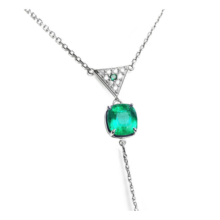 Natural cushion cut emerald necklace prong set in 14k white gold, dangling from a triangle shaped gold with pave diamonds center piece
