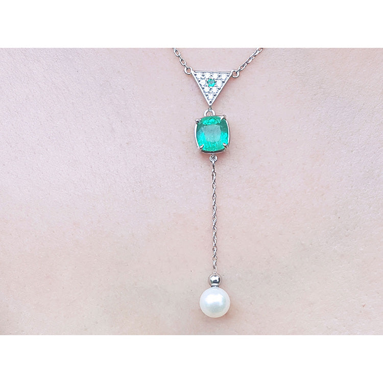 Emerald and pearl necklace cushion cut prong set in 14k white gold, dangling from a triangle shaped gold with pave diamonds