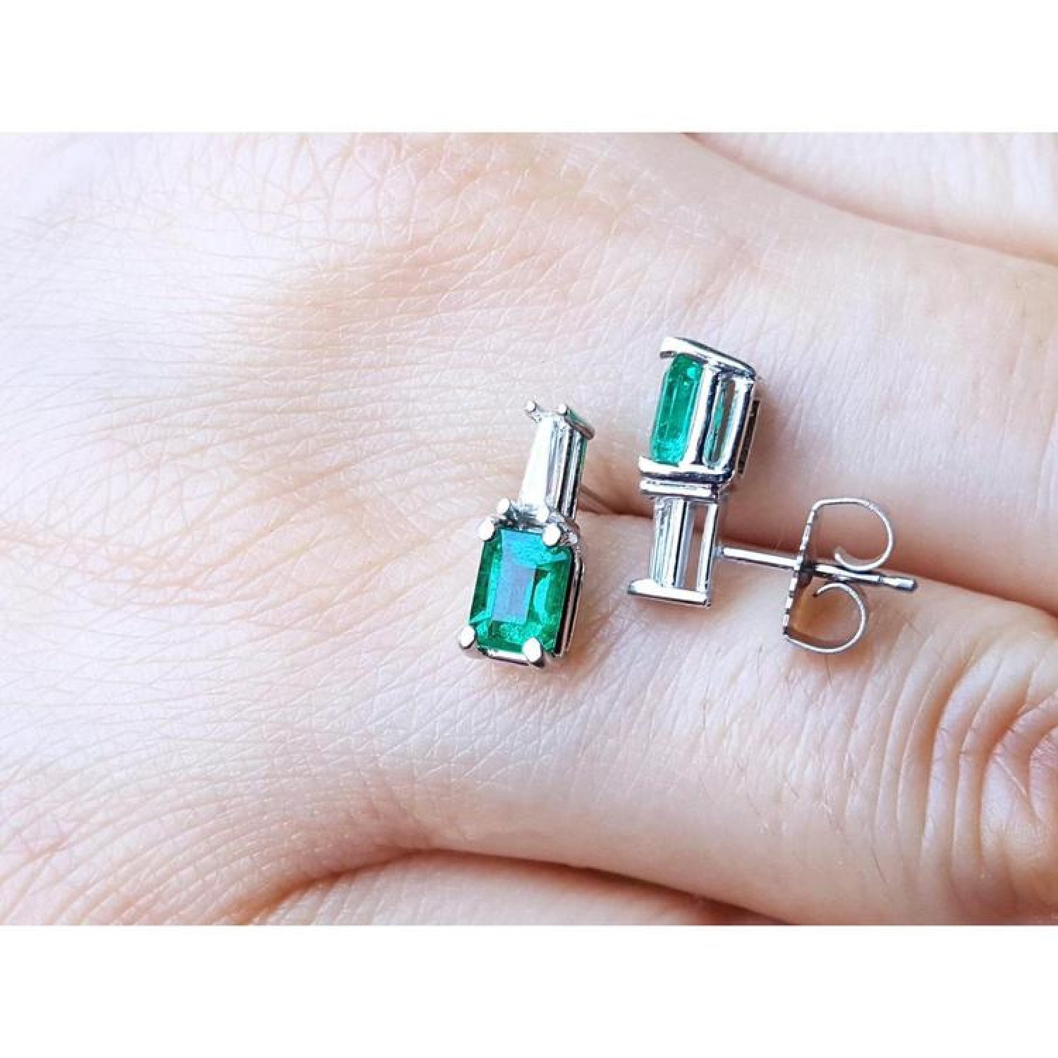 Colombian emerald and baguette diamond stud earrings in 14K white gold, featuring rectangular emerald-cut gems.