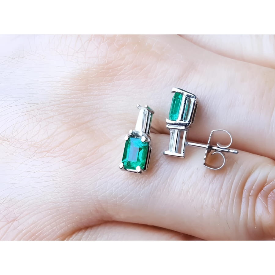 Colombian emerald and baguette diamond stud earrings in 14K white gold, featuring rectangular emerald-cut gems.