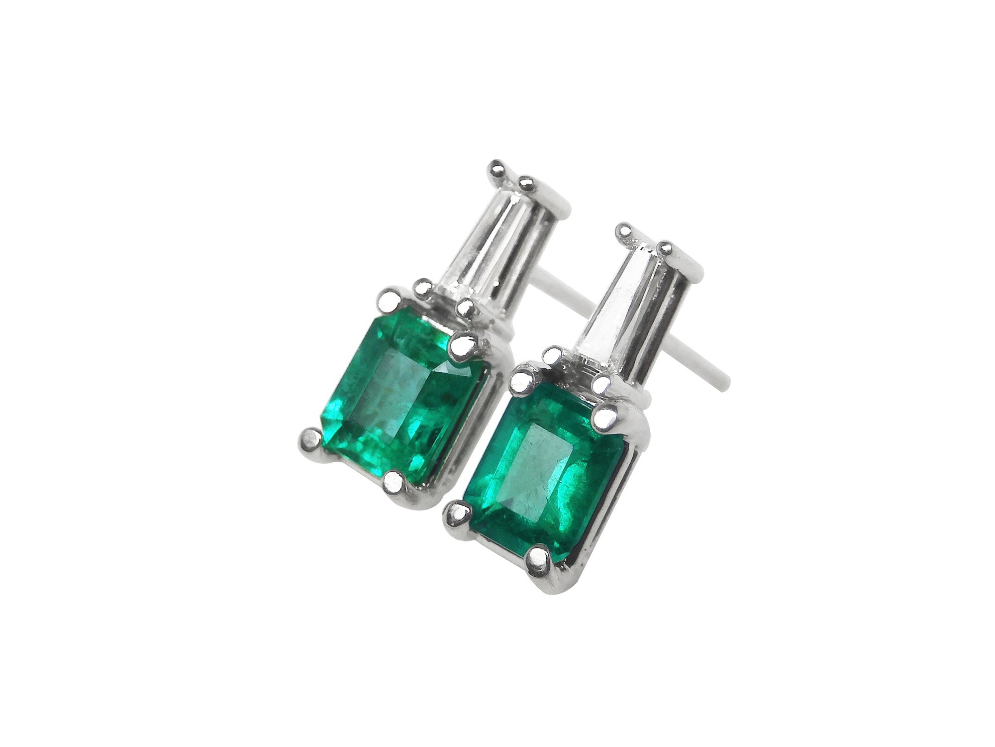 A pair of Colombian emerald and baguette diamond stud earrings, left side profile view.