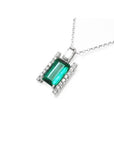 Baguette cut Colombian emerald and diamond pendant necklace in 14K white gold.