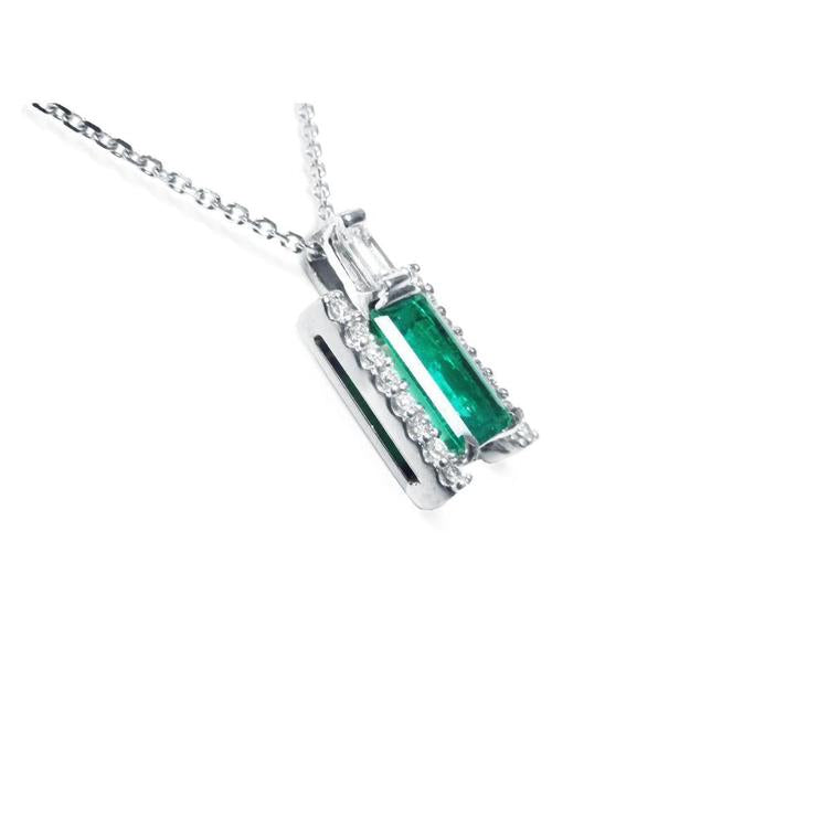 A white gold emerald baguette pendant with accent diamonds displaying the right-side gallery profile view.