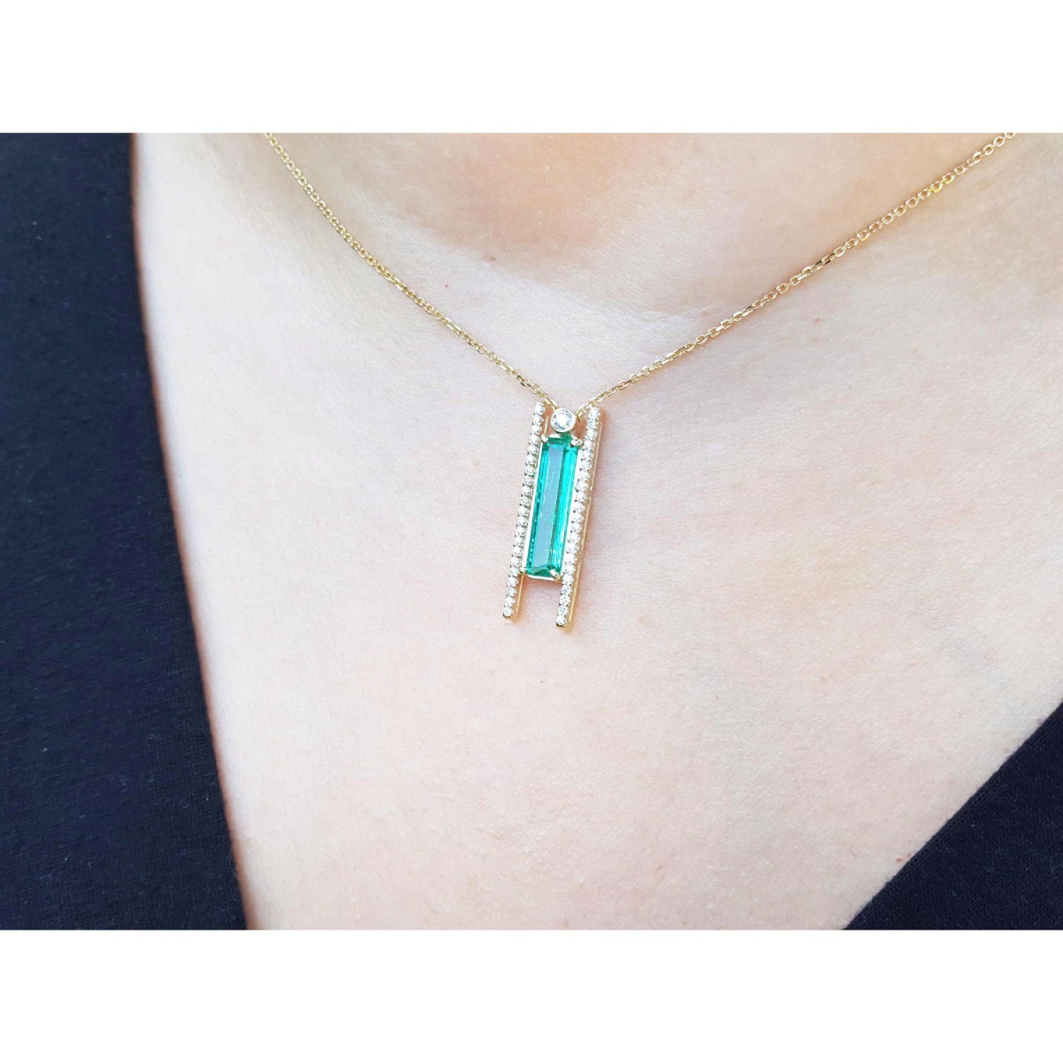 Emerald baguette cut necklace with natural diamonds, 14K yellow gold chain, and unique sliding tube bail.